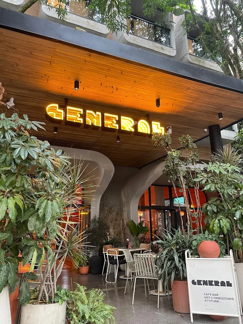 modern cafe entrance with yellow neon "general" sign and lush plants., general cafe bar medellín, medellín
