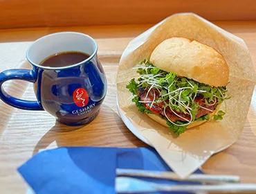blue mug with coffee, sandwich with fresh greens on wooden table., geshary coffee hibiya, tokyo