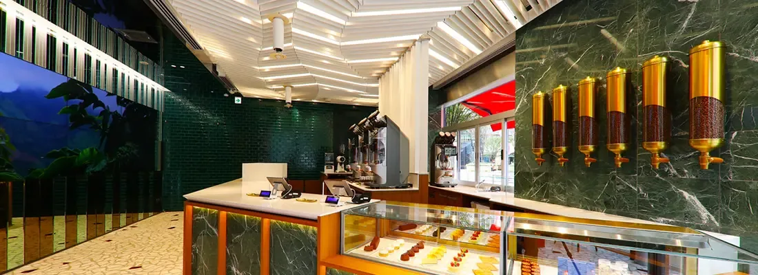 modern jewelry or luxury retail store with green marble walls and gold pendant lights., geshary coffee hibiya, tokyo