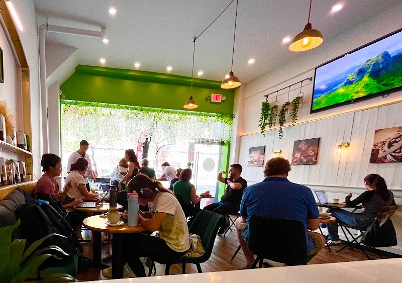 busy café interior with green accents, customers seated at tables, natural light from large windows., gold coffee, new york c