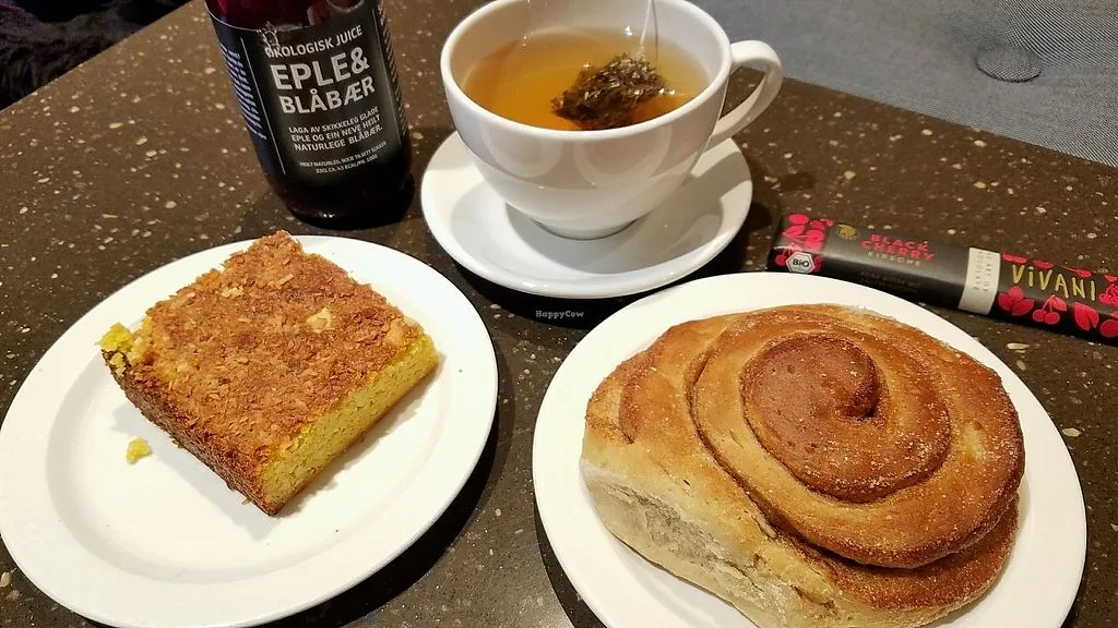 pastries and tea on a speckled table with juice bottle and chocolate bar., good bread floyen, bergen