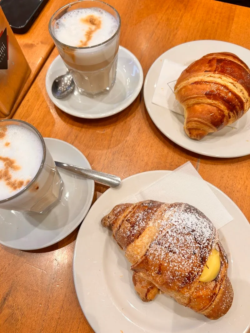 breakfast spread with pastries, croissants, and cappuccinos on wooden table., gran caffè cimmino, naples