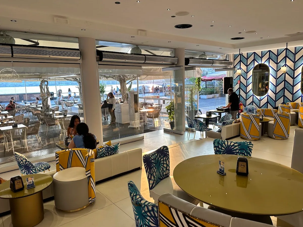 modern beachfront café with geometric patterned chairs and circular tables, ocean views., gran caffè cimmino, naples