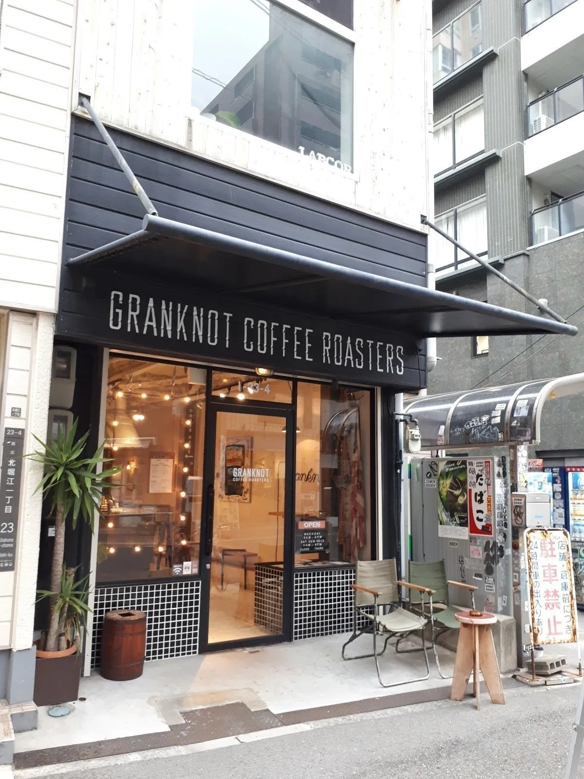 granknot coffee roasters storefront with black awning, warm lighting, and potted plants outside., granknot coffee, osaka