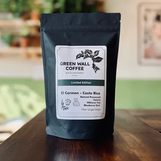 dark roasted coffee bag labeled "green wall coffee" on wooden table indoors., green wall coffee, berlin