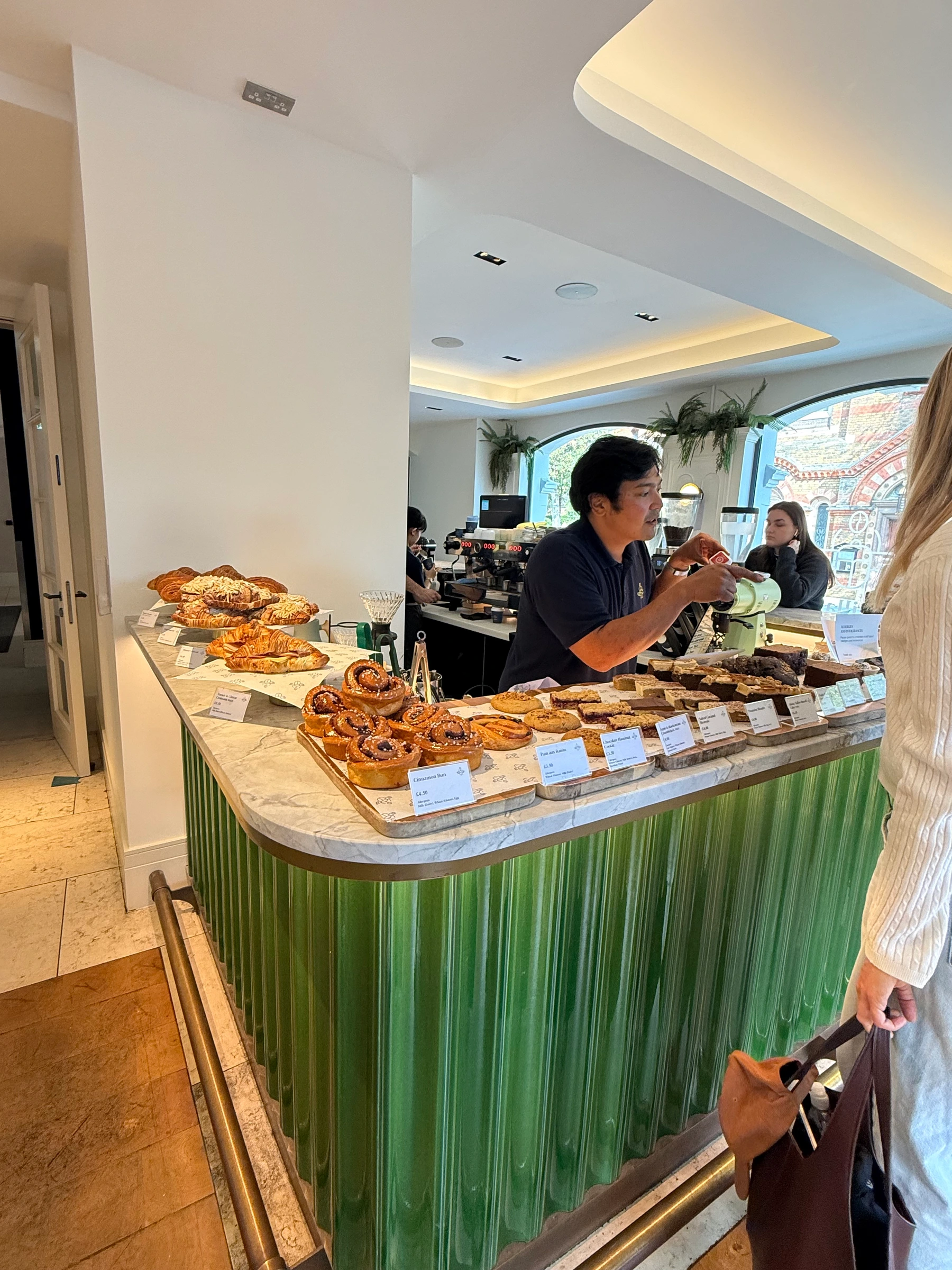 barista at the bar pulling espresso, bakes on the marble counter at guillam bayswater