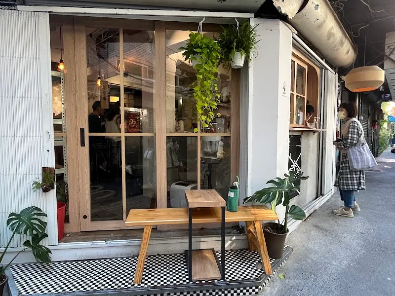 modern storefront with wooden table, checkered floor, hanging plants, and glass doors., ハーフ珈琲（hafu coffee roaster), taipei