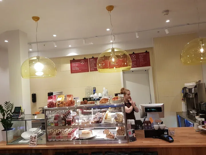 modern bakery counter with golden pendant lights and display cases of pastries., hallaisen ice cream & desserts, bergen