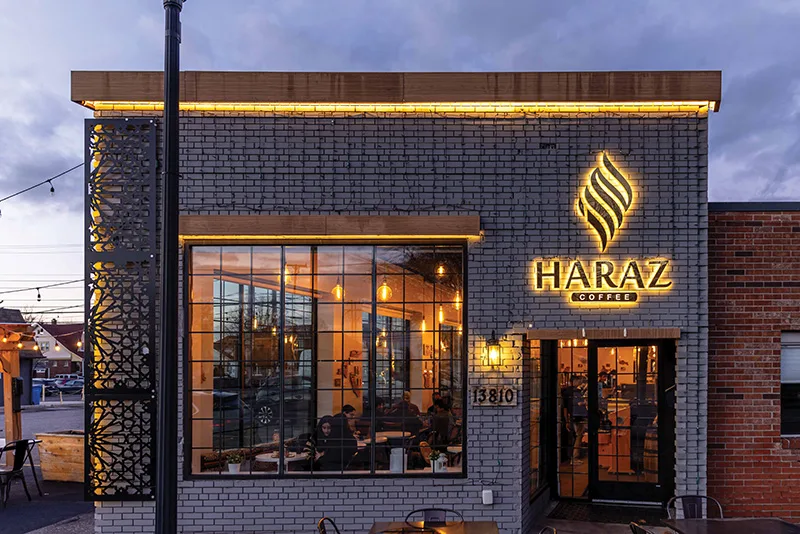 illuminated haraz coffee storefront with brick facade and large windows at dusk., haraz coffee house, detroit