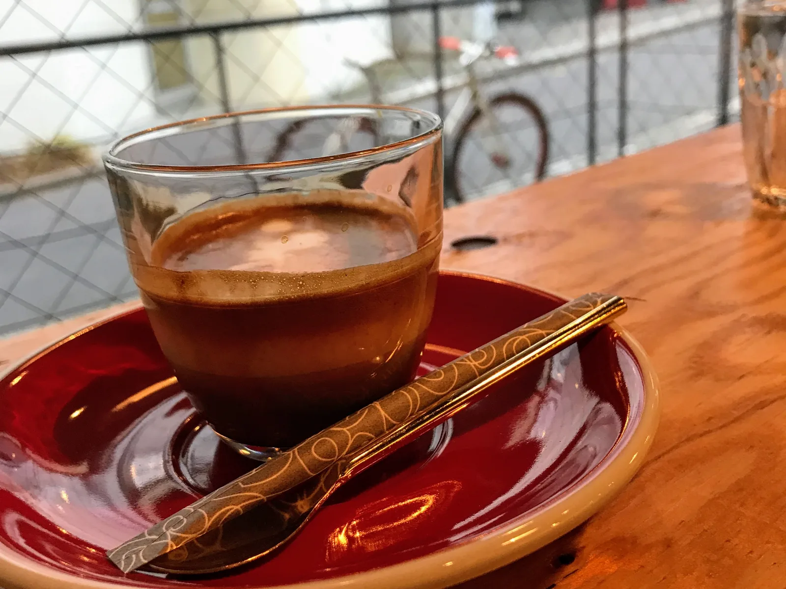 coffee cup on red saucer with decorative spoon at wooden table., heart's light coffee, tokyo