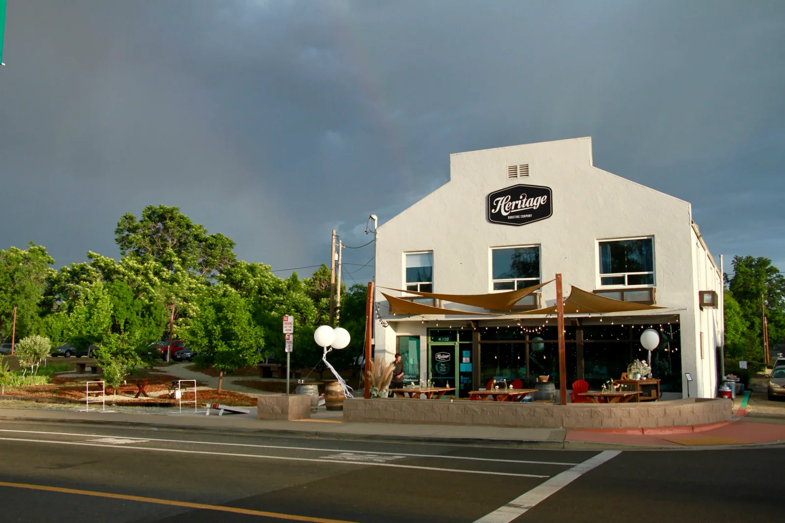 white corner building with heritage roasting company sign and covered patio seating., heritage coffeehouse in shasta lake, re
