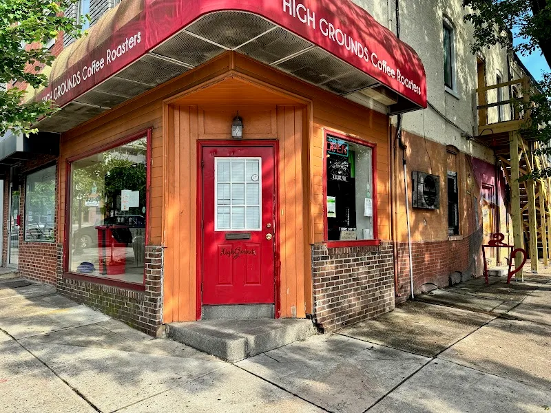 high grounds coffee roastery storefront with red door and wooden trim on corner building., high grounds coffee roasters and b