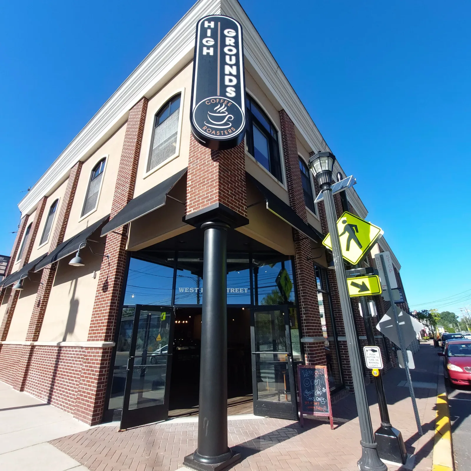 high grounds coffee roastery corner storefront with brick facade and signage., high grounds coffee roasters and books, baltim