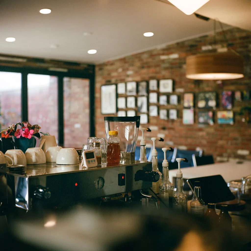 modern café counter with espresso machine, flowers, and exposed brick walls., hinterhof coffee, louisville
