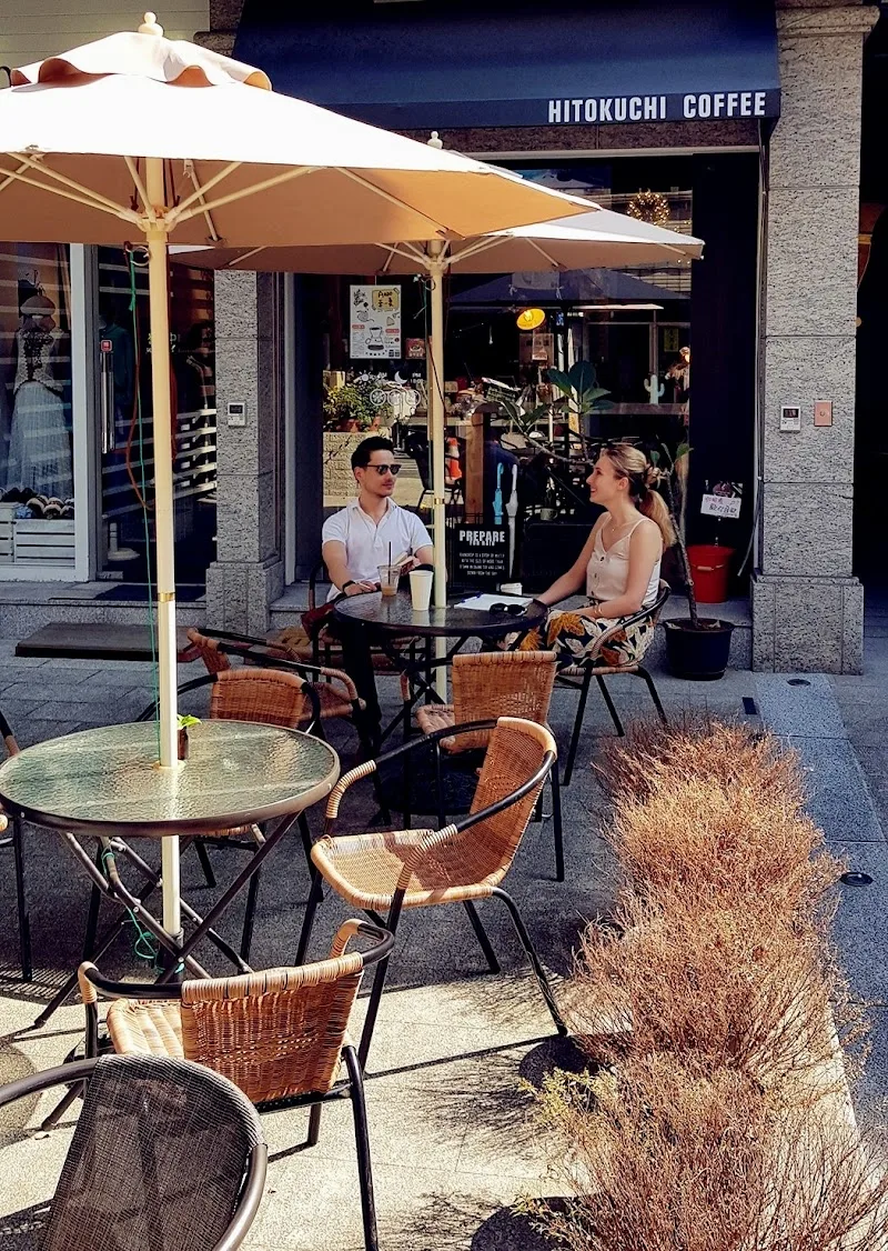 hitokuchi coffee outdoor seating area with two customers under cream umbrellas., hitokuchi coffee, taipei