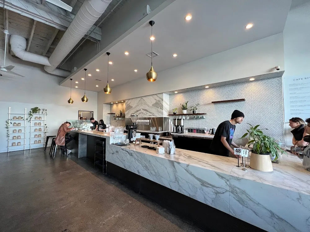 modern coffee shop interior with marble counter, pendant lights, and industrial ceiling., holsem coffee, san diego