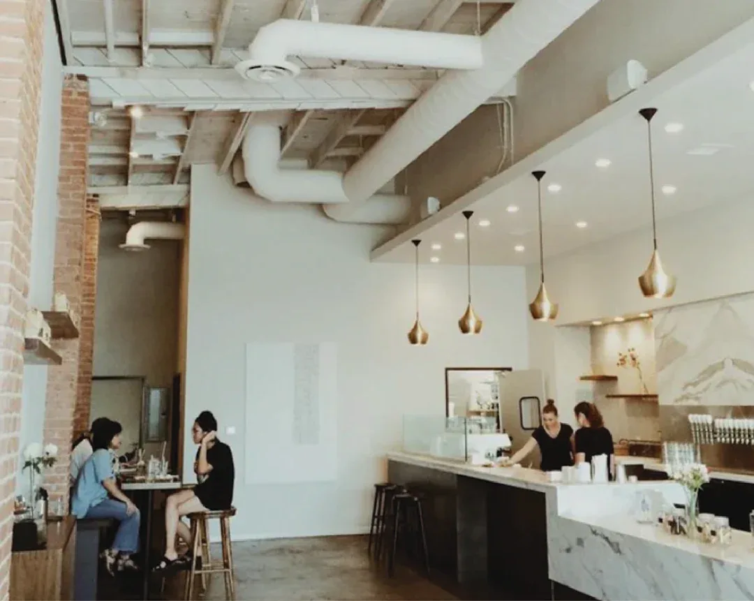 modern café interior with exposed brick, high ceilings, pendant lighting, and marble counter., holsem coffee, san diego