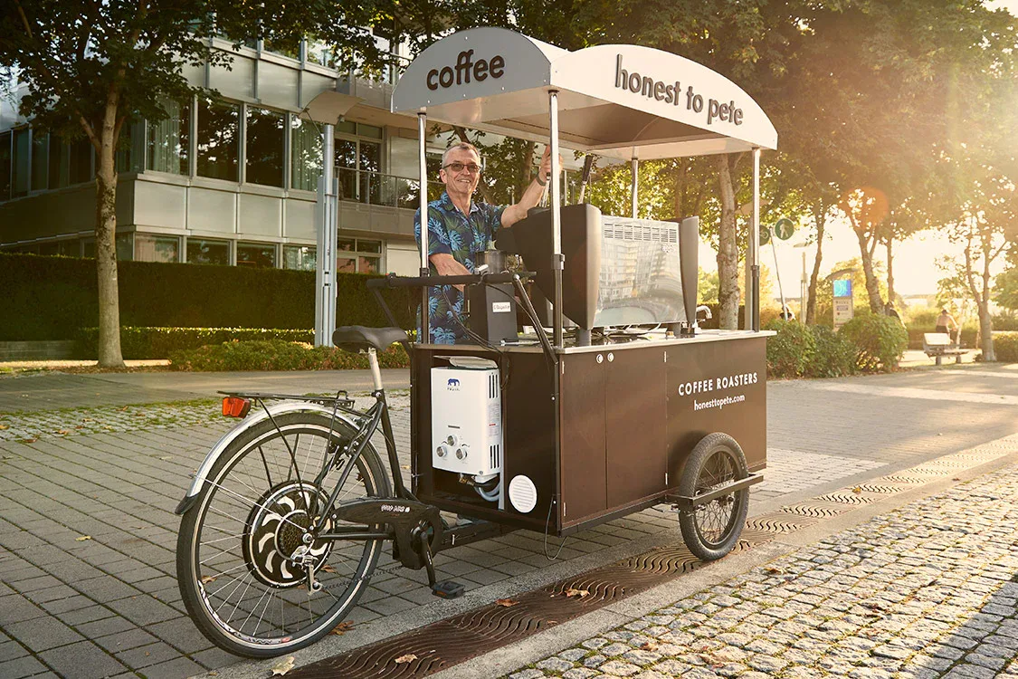 man operates mobile coffee cart with "honest to pete" branding on tree-lined street., honest to pete coffee roasters, vancouv