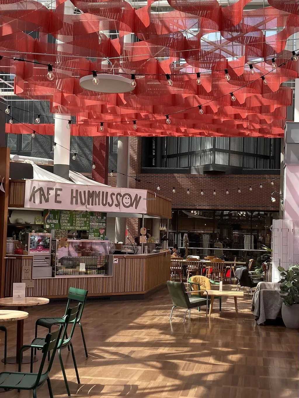 modern café interior with red fabric canopy, brick building, wooden counter, and seating area., hummusson, malmö