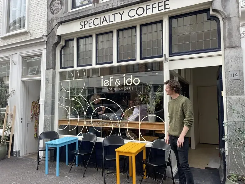 specialty coffee shop storefront with colorful outdoor seating and geometric window design., ief&ido coffee roasting shop/bar