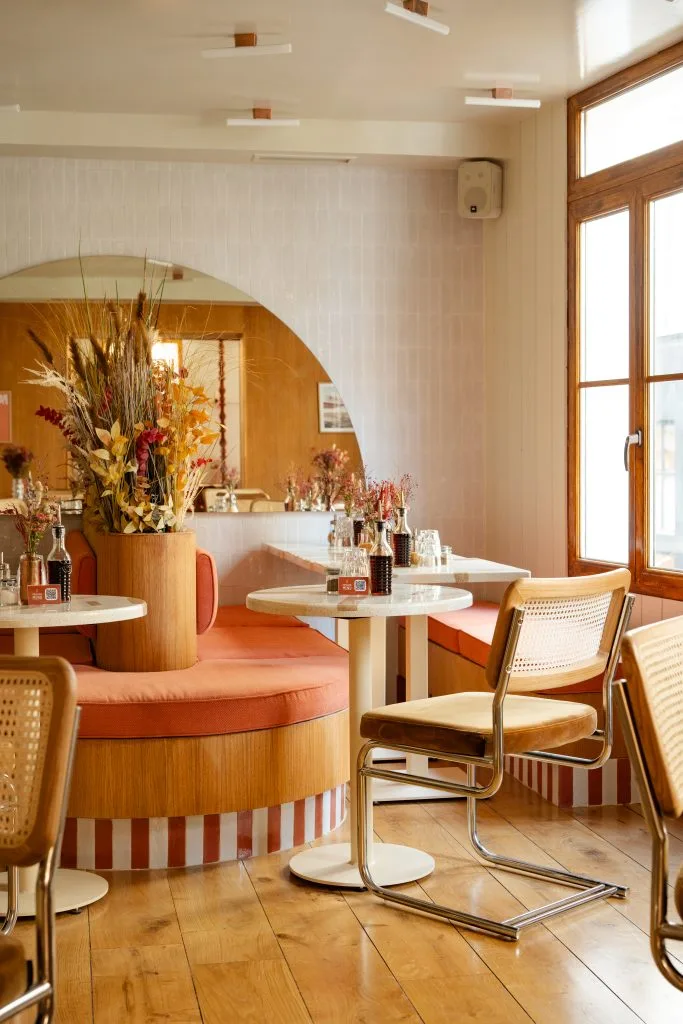 warm-toned café interior with curved wooden booth seating and round tables., immersion sentier - brunch & coffee, paris