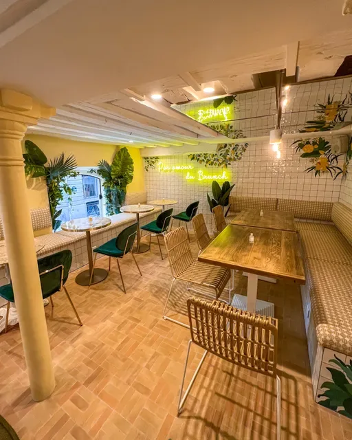 modern café interior with wooden tables, green plants, neon signage, and natural lighting., immersion vendôme - brunch & coff