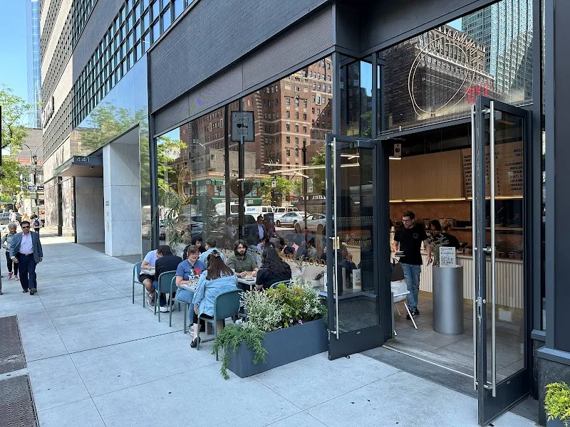 urban sidewalk cafe with diners seated outside modern storefront building., incommon, new york city