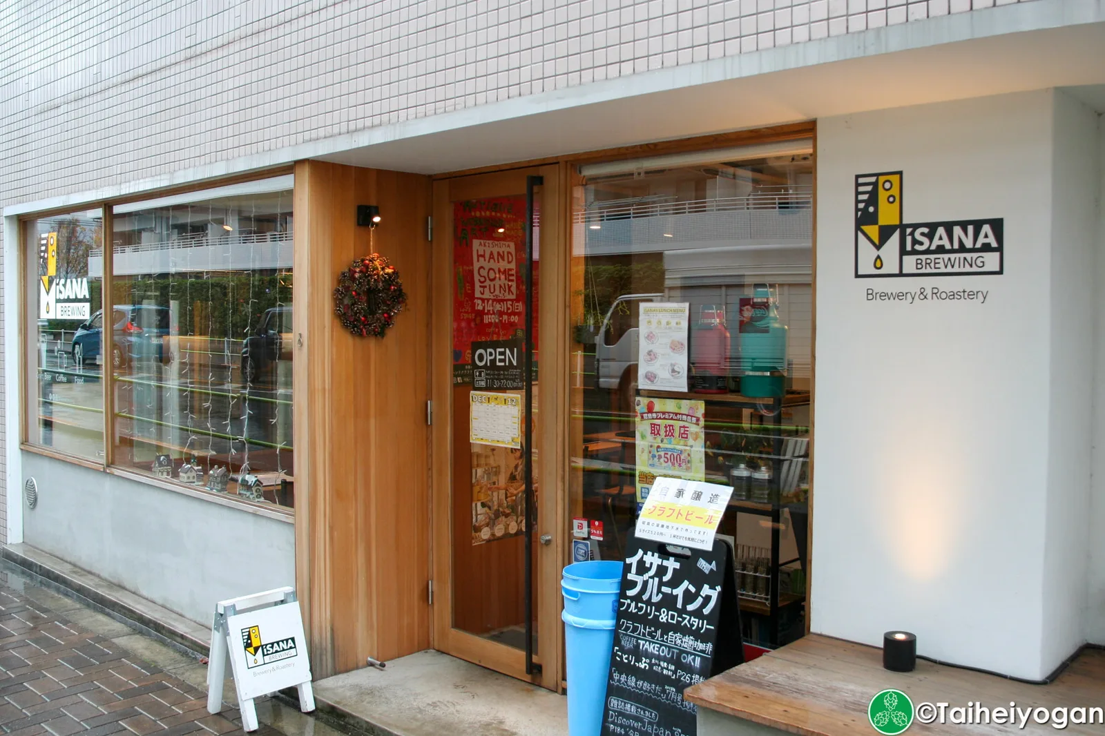 isana brewing storefront with wooden door, "open" sign, and blue bucket outside., isana brewing brewery & roastery, tokyo