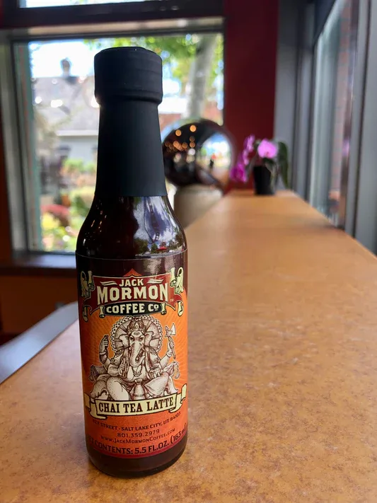 jack mormon coffee company chai tea latte bottle on wooden counter by window., jack mormon coffee roasting, salt lake city