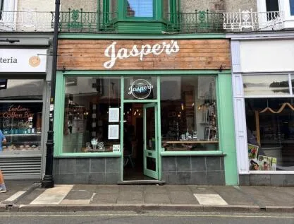 green-fronted jaspers storefront with wooden signage on urban street corner., jasper's coffee house, keswick