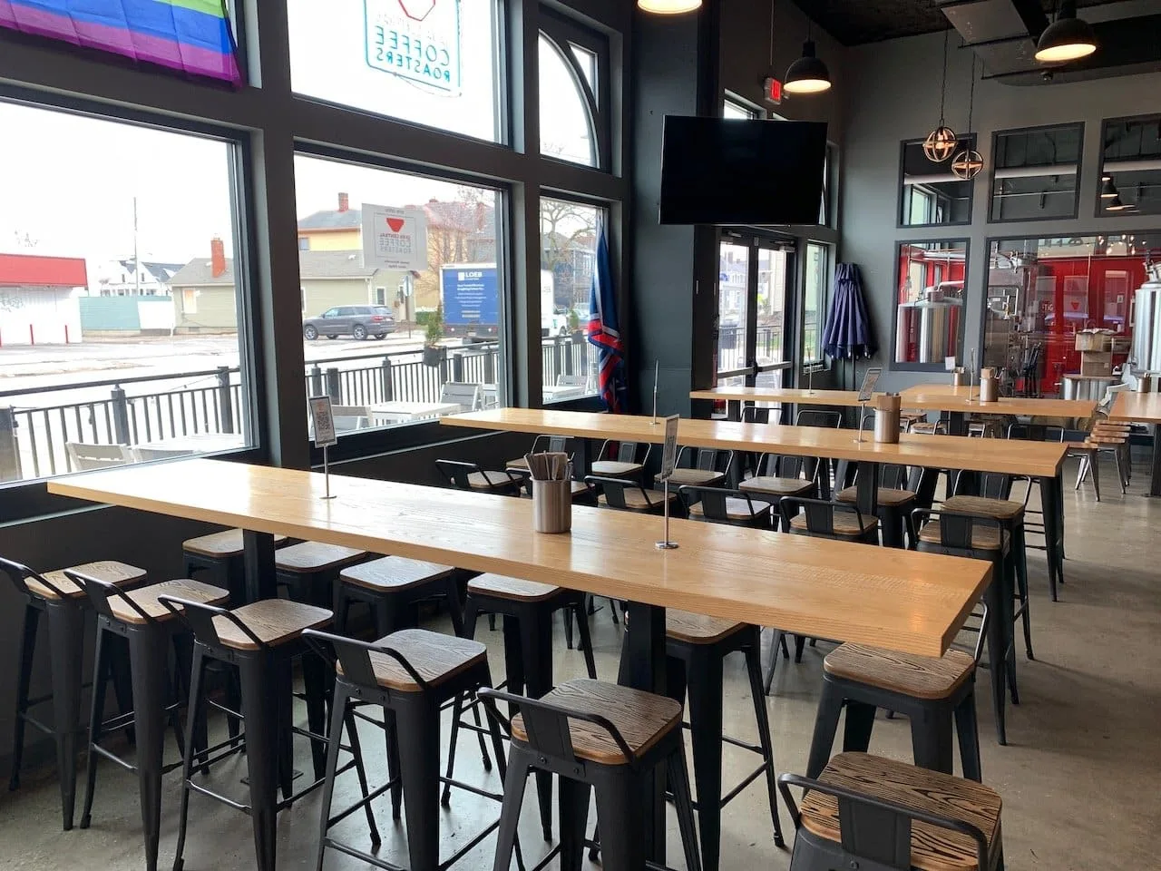 modern restaurant interior with wooden tables, bar seating, and large windows overlooking street., java central, columbus