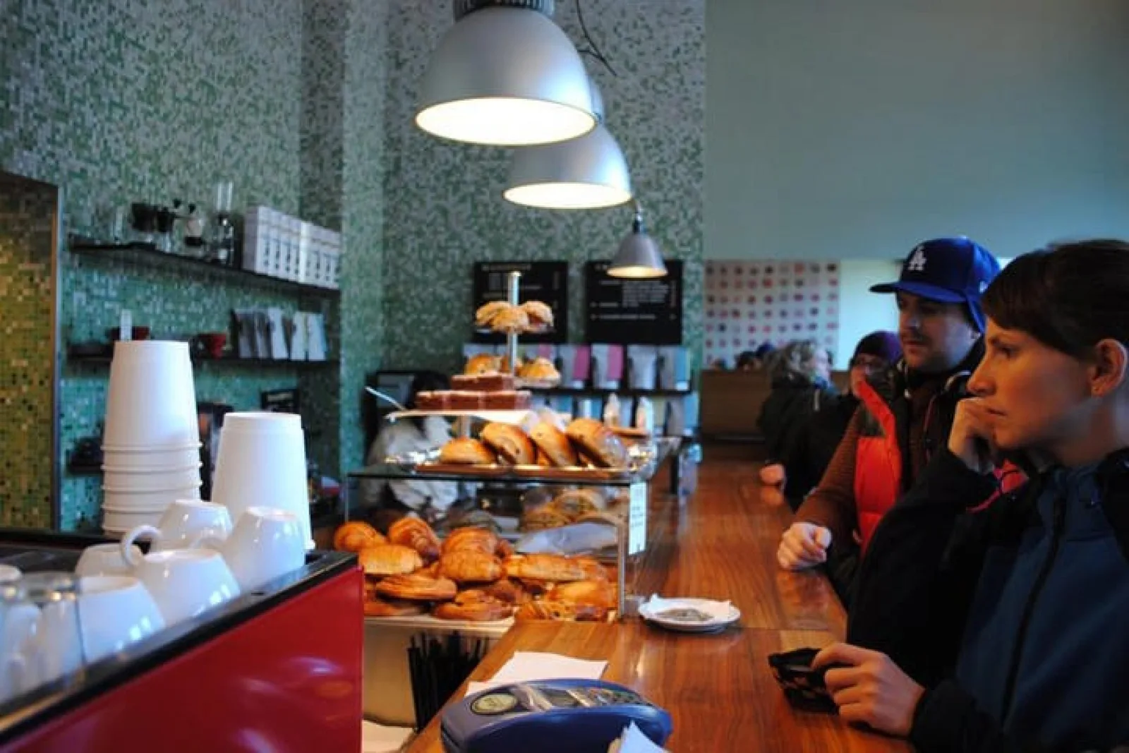 modern bakery café with customers, pastries display, and contemporary pendant lighting., java espresso & coffee business as, 
