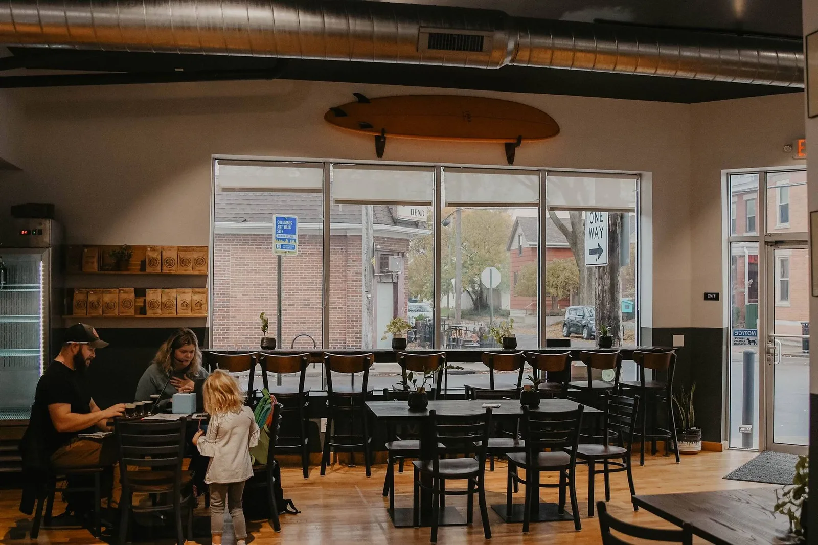 modern café interior with surfboard décor, large windows, wooden tables and black chairs., jennings java, columbus
