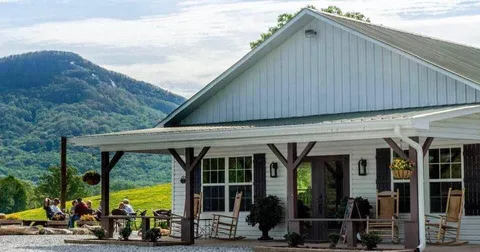 modern farmhouse with covered porch overlooking green mountain valley landscape., jumpingoat coffee roasters and tasting room
