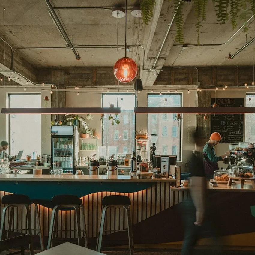 modern industrial café with bar seating, red pendant light, and large windows overlooking city., kaapeh, sherbrooke