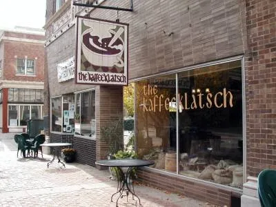 brick storefront with signage for "the käseplätsch" café and restaurant establishment., kaffeeklatsch, huntsville