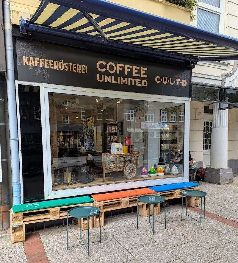 coffee shop storefront with colorful outdoor seating made from wooden pallets., kaffeerösterei coffee unlimited, hamburg