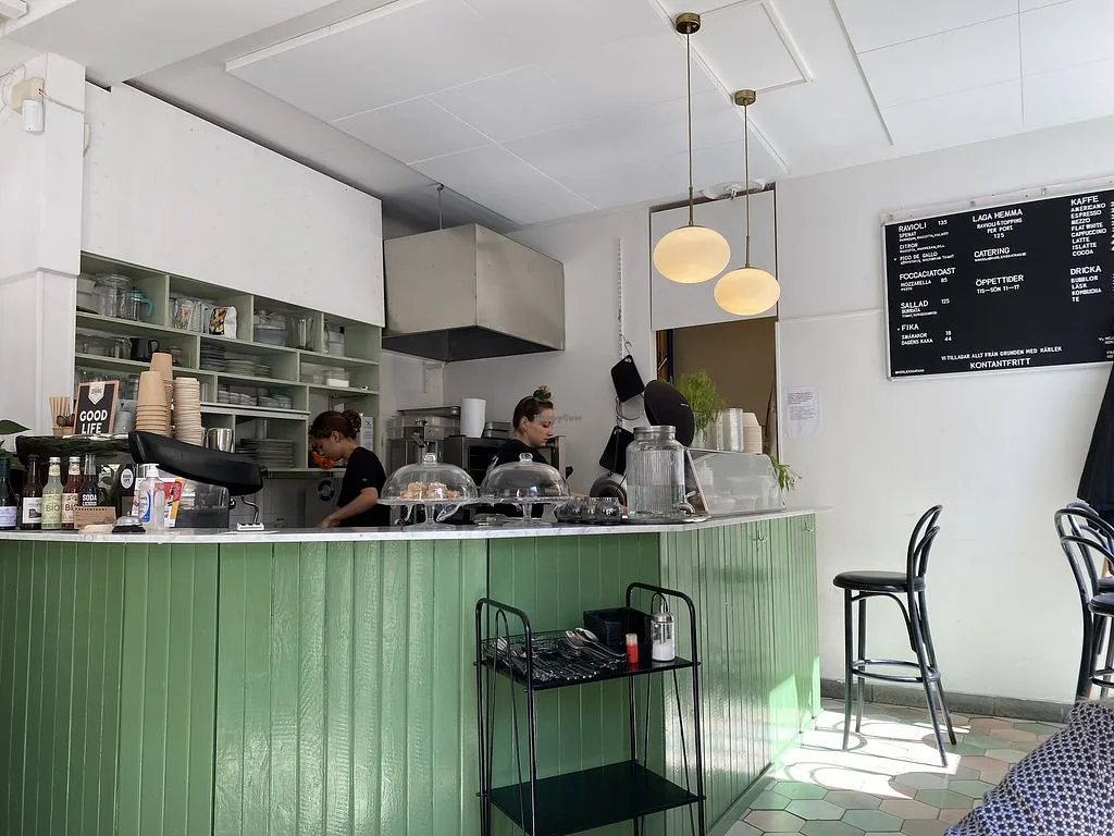 modern café with green counter, pendant lights, and menu board on wall., kärleksgatan 3, malmö