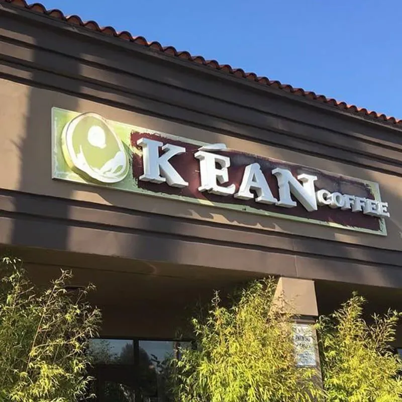 kran coffee storefront with illuminated signage and green foliage below., kean coffee, newport beach