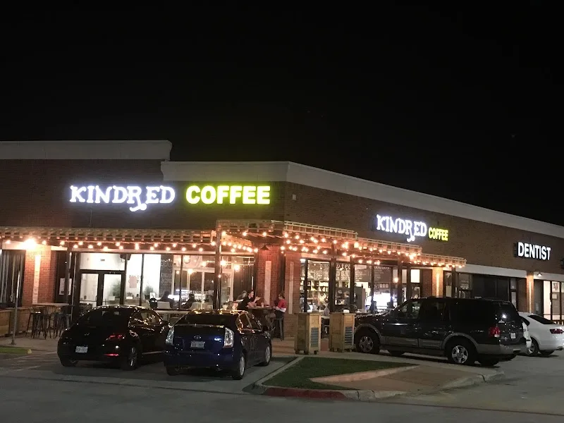 kindred coffee storefront illuminated at night with parked vehicles in front., kindred coffee co., north richland hills