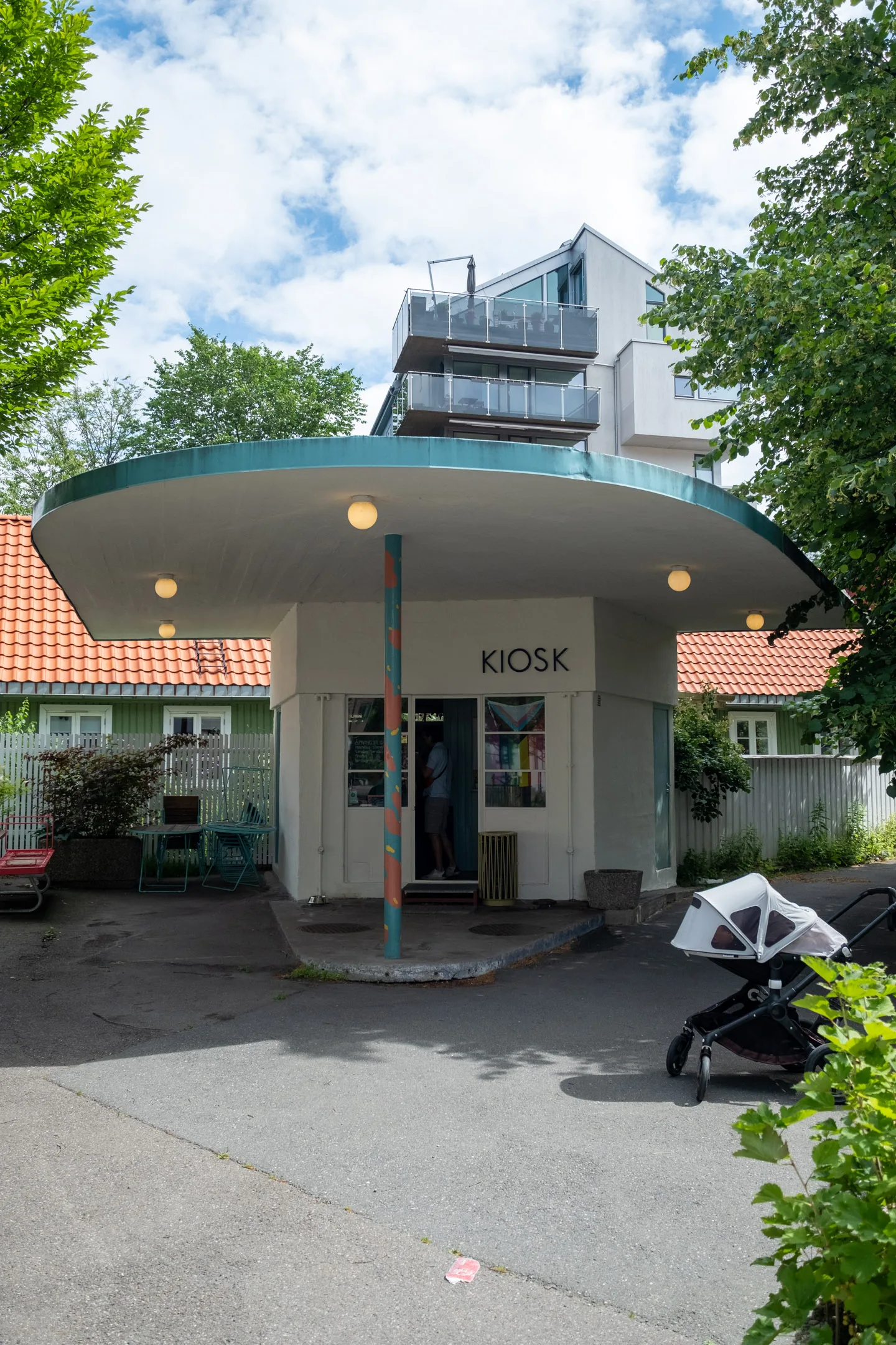 modernist kiosk with turquoise roof among traditional swedish cottages and trees., kiosk! oslo, oslo