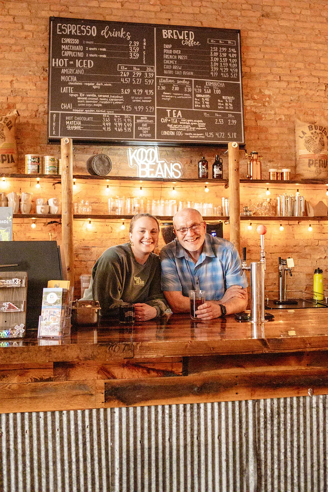 two people smile behind wooden counter at kool beans coffee shop., kool beans coffee and roasterie, brookings