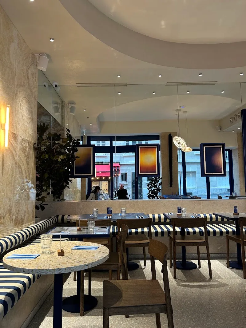 modern restaurant interior with striped banquettes, marble tables, and curved ceiling design., kozy south pigalle | all-week 