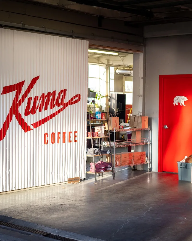 kuma coffee storefront with red signage and industrial interior space., kuma coffee, washington