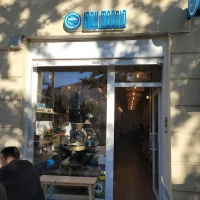 small storefront with blue signage, dark entrance door, and street-level window display., lady madrid roaster y speciality co