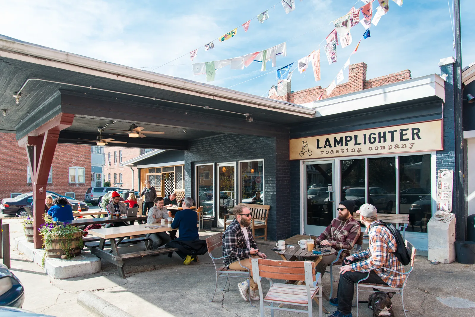 lamplighter roasting company outdoor patio with customers and colorful bunting overhead., lamplighter roasting company roast 