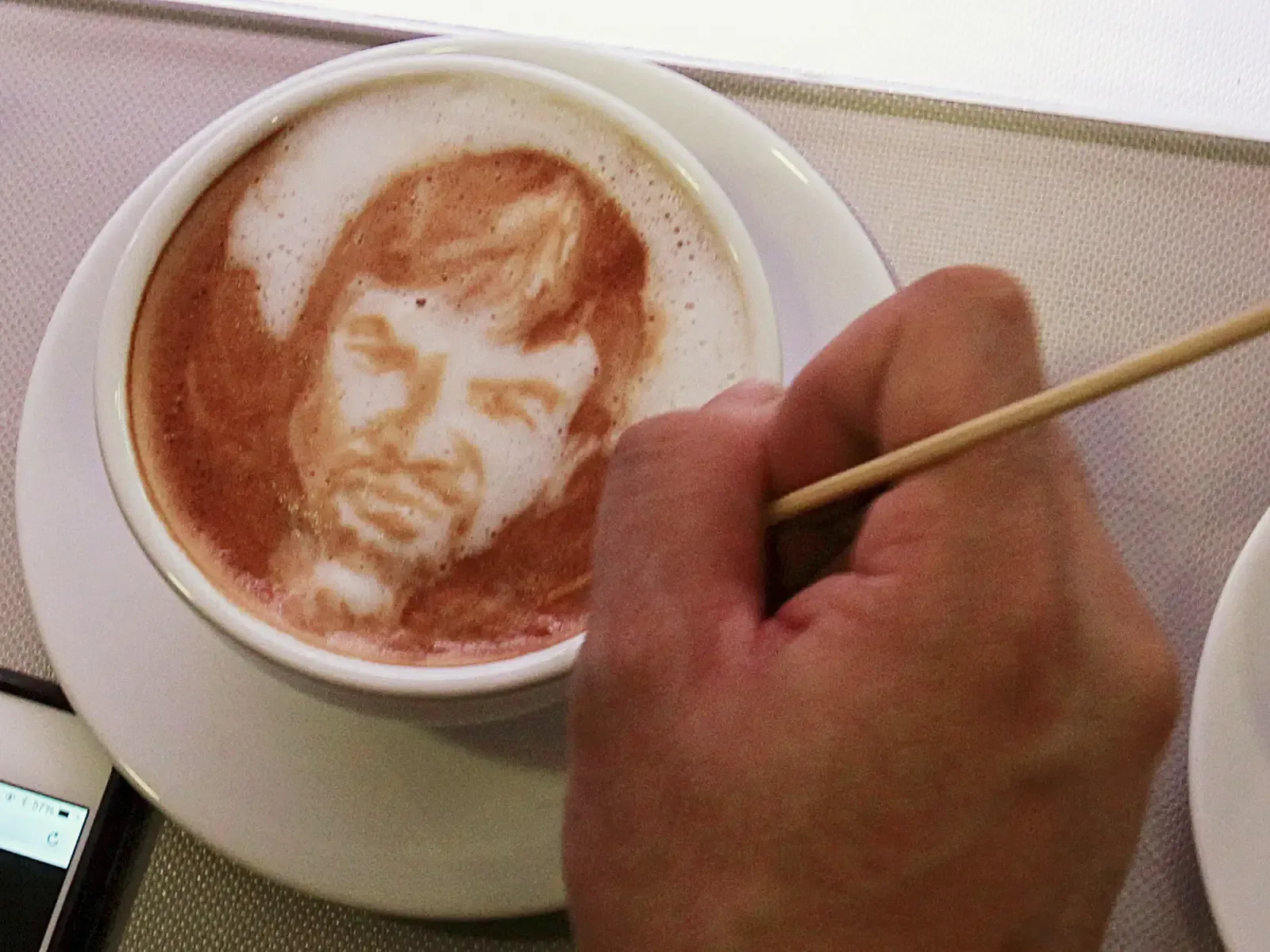 hand creating latte art portrait of a bearded man in cappuccino cup., latte'liê art in coffee, são paulo