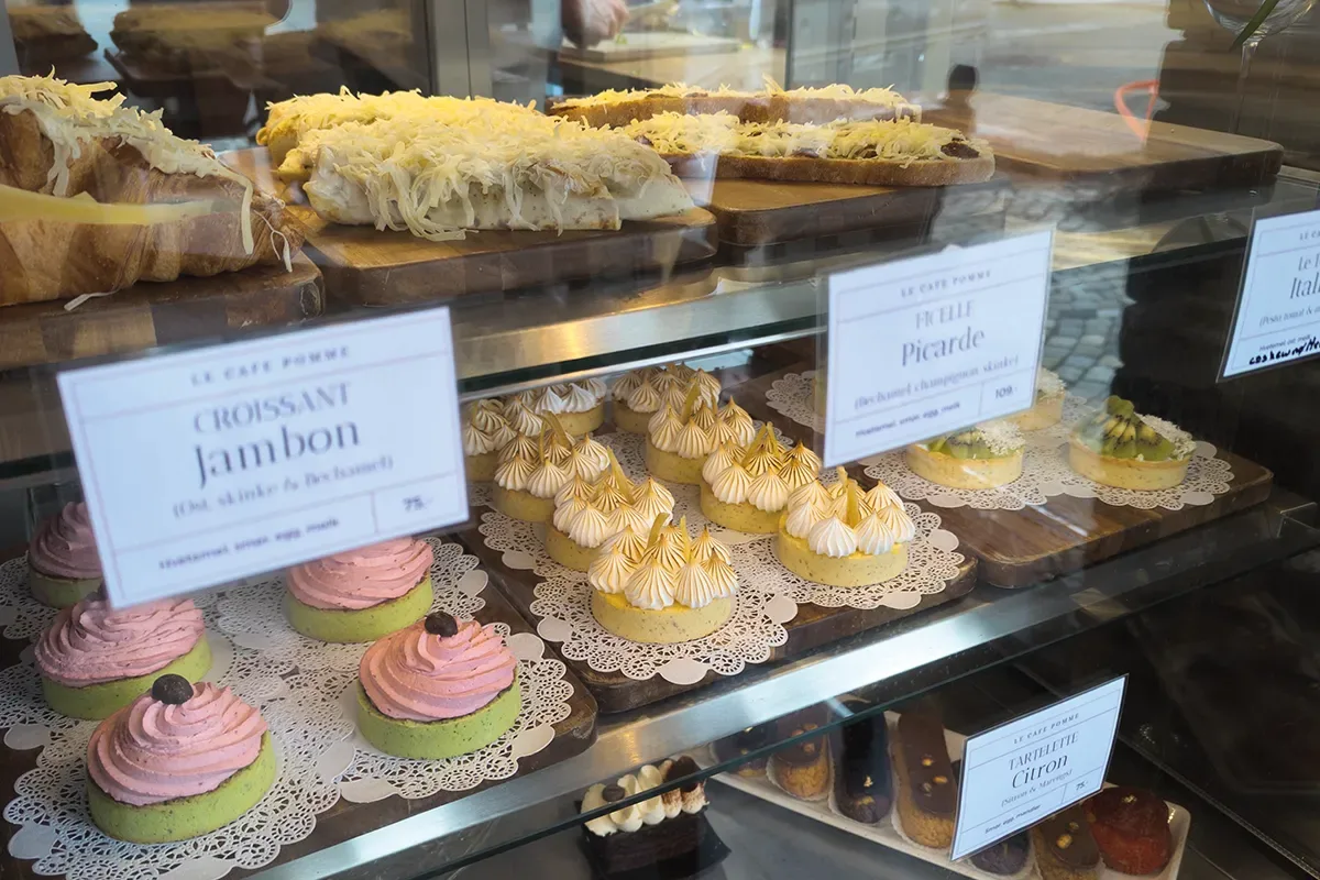 bakery display case with croissants, pastries, cupcakes, and french desserts., le café pomme, bergen