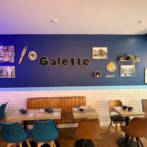 modern restaurant interior with "galette" signage, booth seating, and decorative wall art., le p'tit breton | lorette, paris