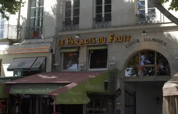 parisian street-level café with green awning and residential apartments above., le paradis du fruit, paris